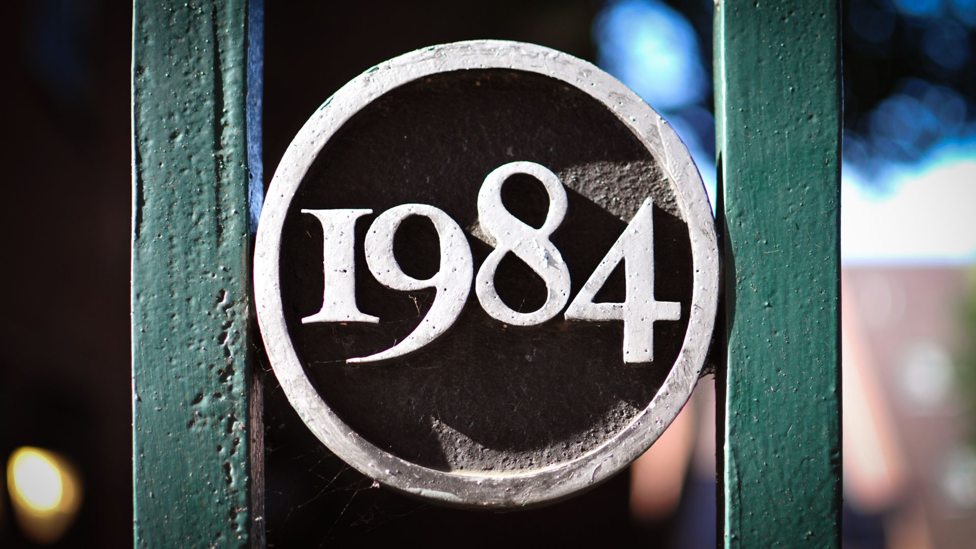 Piece of metal lettering reading 1984, fixed between two metal beams.