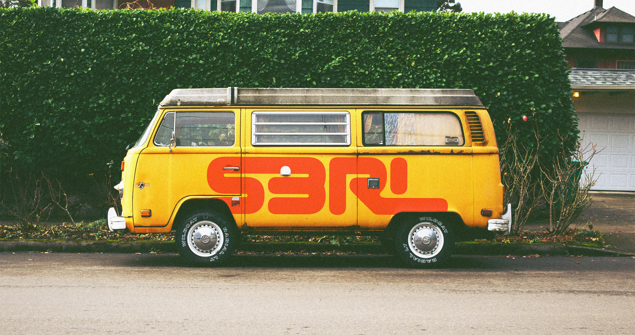 S3RL logotype in red, painted on a yellow van.
