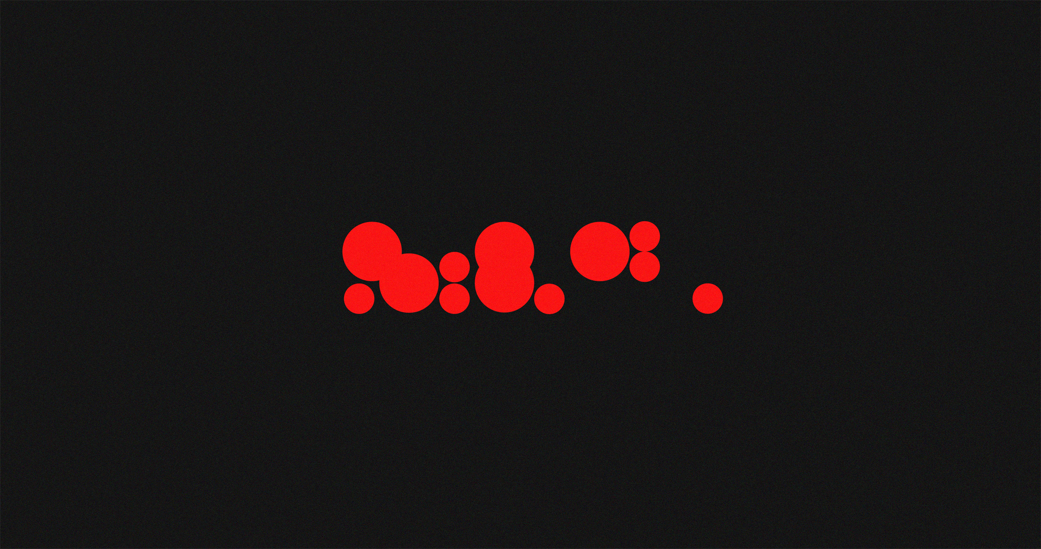 Proportionally-sized red circles arranged in a grid-like manner, covering a rectangular area. Silhouette for a logotype which appears later in this article.