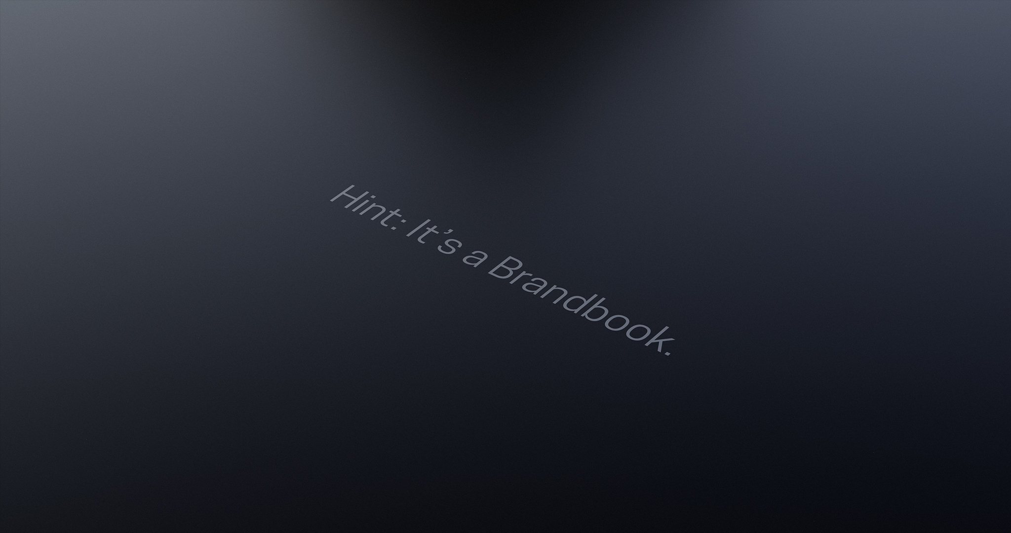 A dark, metallic surface with an engraving that reads: Hint: It’s a Brandbook.