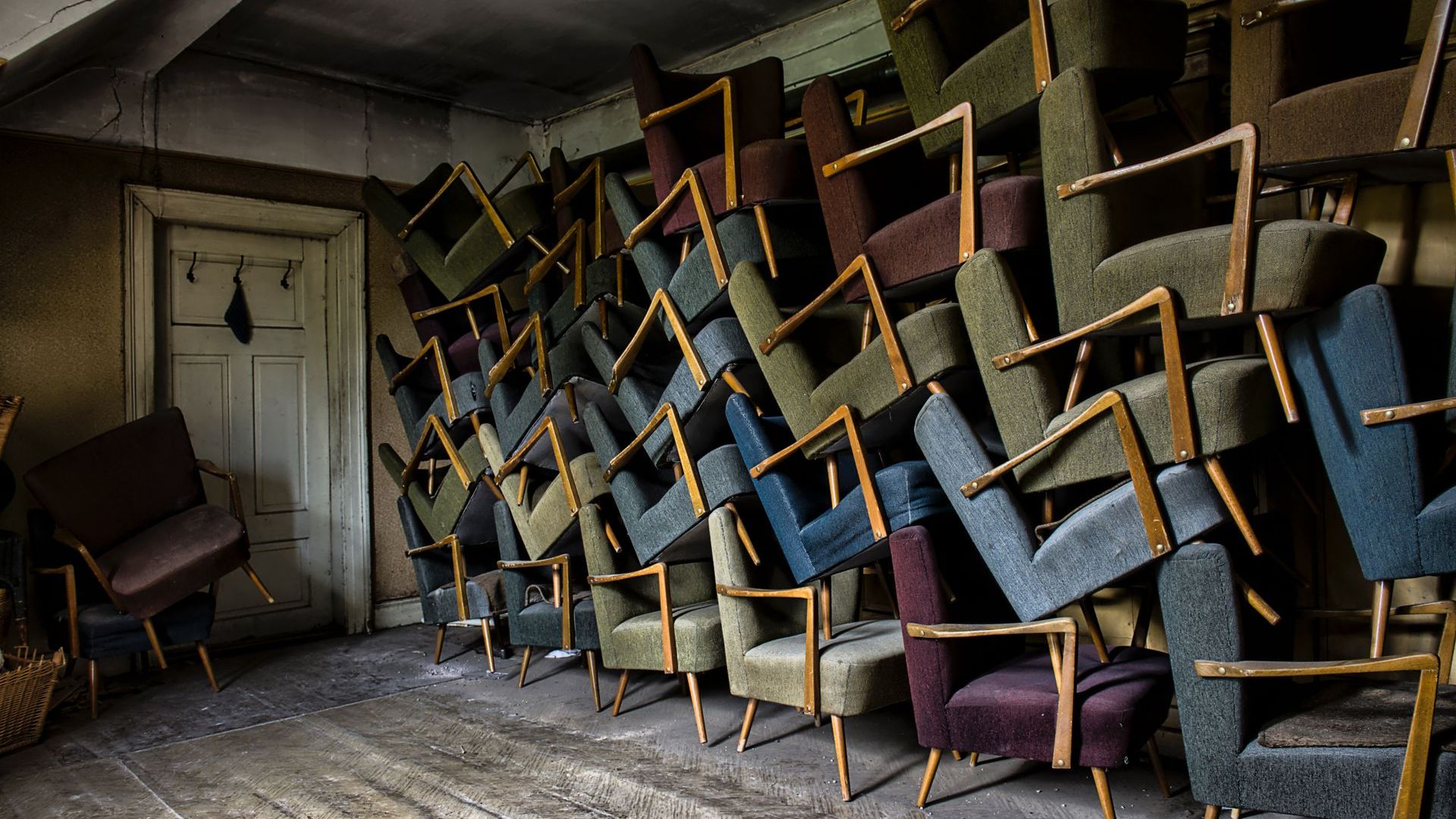 About 29 chairs lined up next to and stacked on one another.