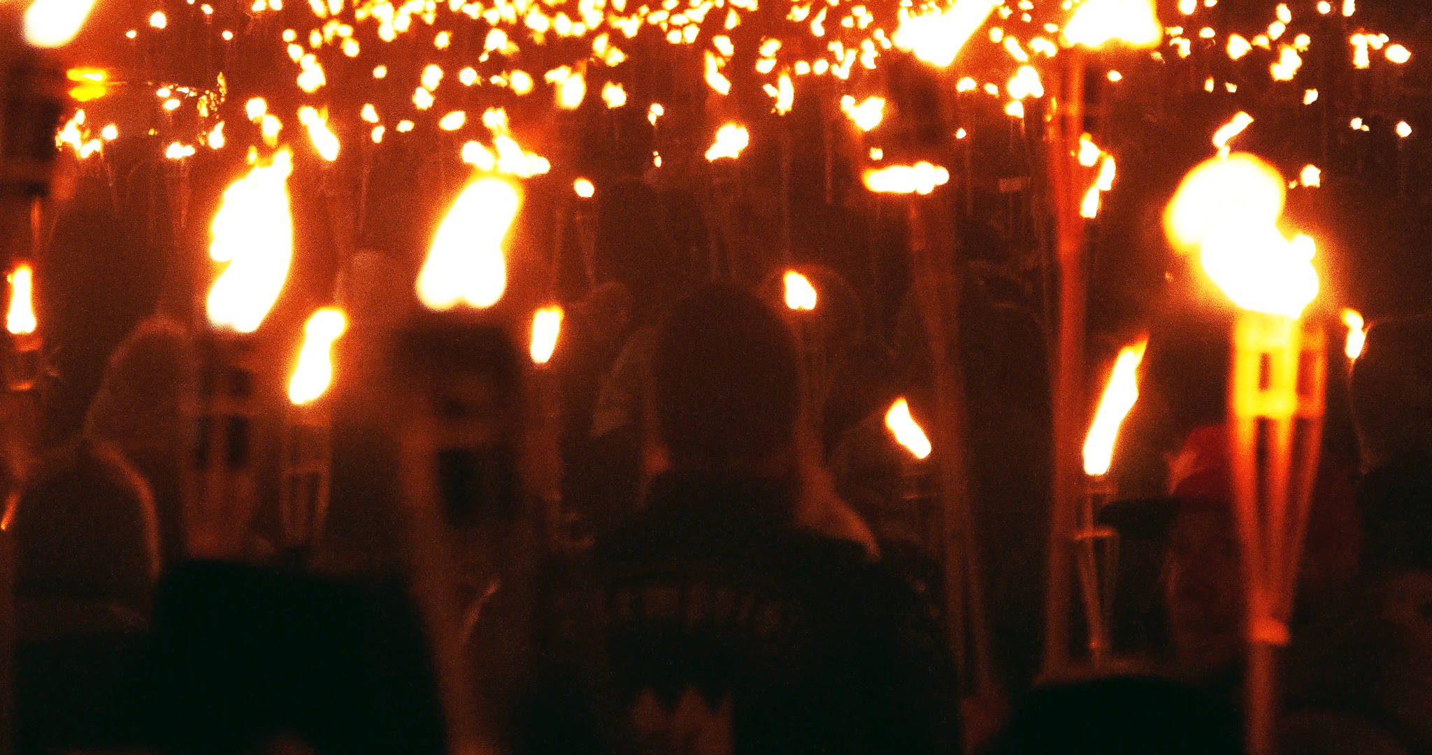 A crowd of protestors holding torches.